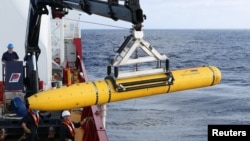 Crew aboard the Australian Defense Vessel Ocean Shield move the U.S. Navy's Bluefin-21 autonomous underwater vehicle into position for deployment in the southern Indian Ocean to look for the missing Malaysia Airlines flight MH370, April 14, 2014 in this h