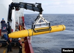 FILE - Crew aboard the Australian Defense Vessel Ocean Shield move the U.S. Navy's Bluefin-21 autonomous underwater vehicle into position for deployment in the southern Indian Ocean to look for the missing Malaysia Airlines flight MH370, April 14, 2014.