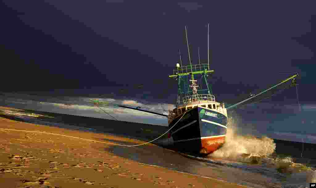 The Carrabassett, a New Bedford-based commercial fishing boat, sits grounded on Longnook Beach in Truro, Massachusetts. Officials are still working to free the boat which ran aground November 30.