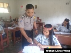 Brigadir Kepala Hans Lapanda mengajar Bahasa Inggris untuk kelas 8 di SD-SMP Negeri Satu Atap desa Bulili, Kecamatan Lore Selatan, Kabupaten Poso, Sulawesi Tengah, 27 April 2018. (VOA/Yoanes Litha)