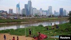 Anak-anak beristirahat setelah bermain bola di bantaran Kali Ciliwung di Jakarta, 12 April 2018.