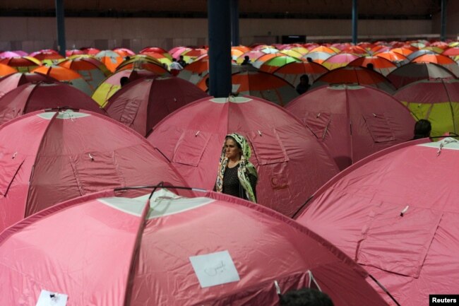 A woman surveys her surroundings as people take shelter at a stadium after a flooding in Golestan province, Iran, March 24, 2019.