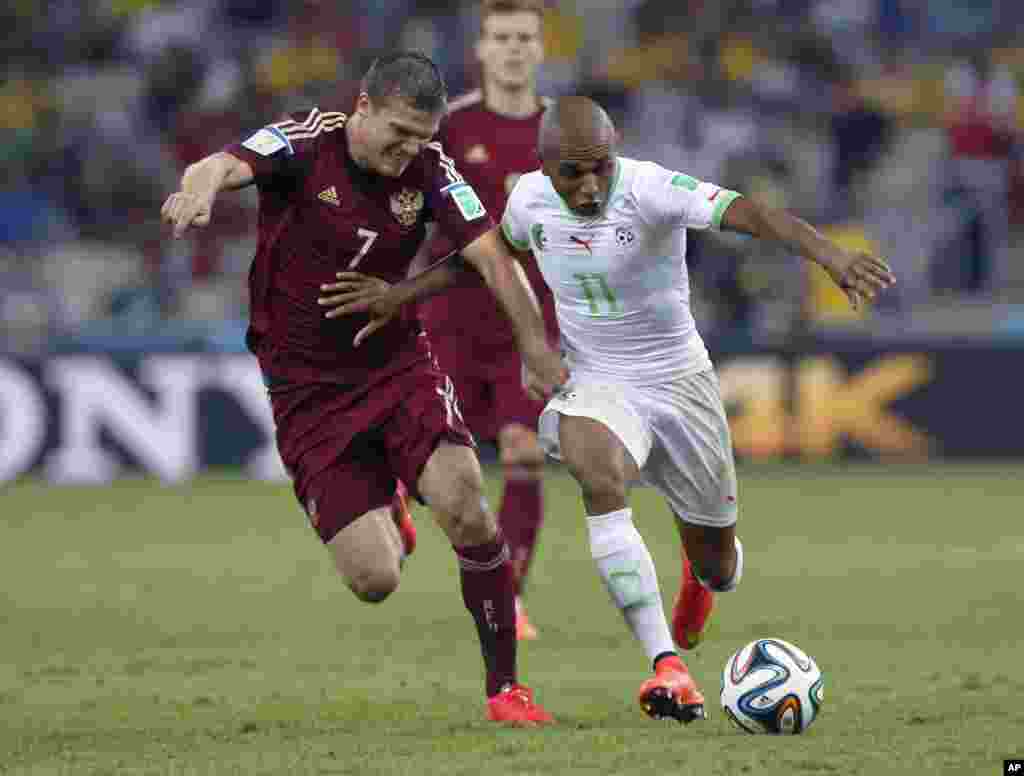 Yacine Brahimi de l&#39;Algérie, à droite, et Igor Denisov de la Russie se battent pour le ballon lors du match de la Coupe du monde du groupe H entre l&#39;Algérie et la Russie à l&#39;Arena da Baixada à Curitiba, au Brésil, jeudi 26 Juin 2014. 