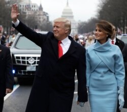 FILE - President Donald Trump waves as he walks with first lady Melania Trump during the inauguration parade on Pennsylvania Avenue in Washington, Jan. 20, 2017.