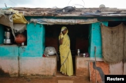 Child bride Krishna, 12, stands at a doorway into her compound in a village near Baran, in India's Rajasthan state, July 30 , 2011.