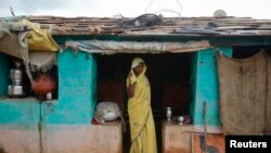 Child bride Krishna, 12, stands at a doorway into her compound in a village near Baran, in India's Rajasthan state, July 30, 2011. Only a quarter of policymakers came close to estimating child marriage rates in their countries, according to a study.