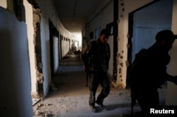 Fighters of Syrian Democratic Forces inspect the bunker of the Islamic State militants under the stadium in Raqqa, Syria Oct. 18, 2017.