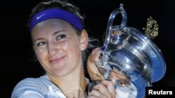 Victoria Azarenka dari Belarus berpose bersama trophy Piala Australia Terbuka setelah mengalahkan Li Na dalam tiga set pada pertandingan final di Melbourne, Sabtu (26/1).