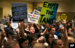 FILE - Opponents and supporters of SeaWorld's whale shows fill the room during a California Coastal Commission meeting in Long Beach, Calif., Oct. 8, 2015.