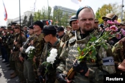 Armed pro-Russia rebels stand guard during celebrations to mark Victory Day in Donetsk, eastern Ukraine, May 9, 2014.