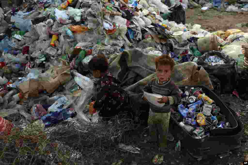 A brother and sister play at a recycling center in Kabul, Afghanistan.