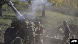 Les soldats arméniens tirent de l'artillerie le 25 octobre 2020, pendant les combats en cours entre les forces arméniennes et azerbaïdjanaises sur la région du Haut-Karabakh. (ARIS MESSINIS / AFP)