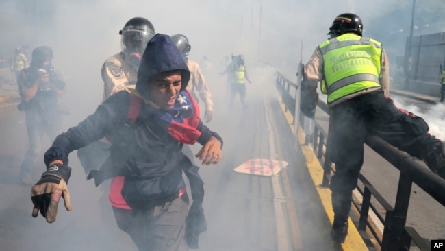 Un manifestante trata de huir de las fuerzas de seguridad durante una manifestación de la oposición al gobierno de Nicolás Maduro en Caracas, el 20 de mayo de 2017.