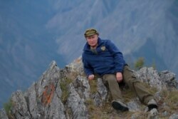 In this undated photo, Russian President Vladimir Putin rests on a hill in Siberia.