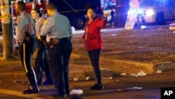 FILE - Police officers interview witnesses, Feb. 25, 2017, at the scene where a vehicle struck a crowd and other vehicles during the Krewe of Endymion parade in New Orleans. Saturday night a car struck a crowd on Esplanade Avenue, near the Endymion parade route.