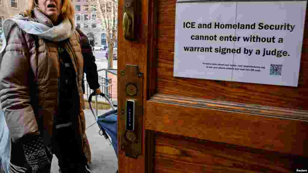 A sign prohibiting ICE and Homeland Security from entering without a warrant is posted on a door at St. Paul and St. Andrew United Methodist Church while a woman enters the church in New York City.