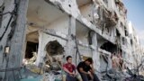 Palestinians sit on the remains of their destroyed homes after returning to Beit Hanoun, which witnesses said was heavily hit by Israeli shelling and air strikes during the Israeli offensive, in the northern Gaza Strip, Aug. 5, 2014.&nbsp;