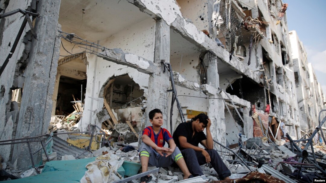 Người Palestine ngồi trên đống đổ nát tại thị trấn Beit Hanoun, sau các vụ không kích của Israel vào phía bắc Dải Gaza, ngày 5/8/2014.
