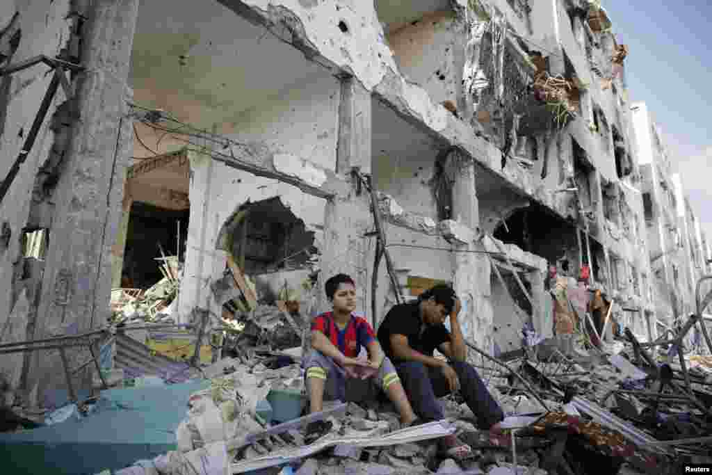 Palestinians sit on the remains of their destroyed homes after returning to Beit Hanoun, which witnesses said was heavily hit by Israeli shelling and air strikes during the Israeli offensive, in the northern Gaza Strip, Aug. 5, 2014.&nbsp;