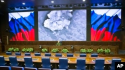 Lieutenant General Sergei Rudskoi of the Russian Military General Staff (background center), speaks to the media in Moscow, March 18, 2016. The screen shows an aerial image of an airstrike during the attack of Russian warplanes in Syria.