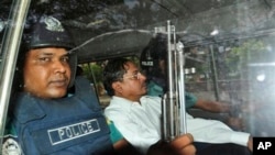 Muhammad Kamaruzzaman, wakil sekjen partai Jamaat-e-Islami, meninggalkan pengadilan dikawal polisi di Dhaka, Bangladesh, Mei 2013. (AP/Khurshed Rinku)