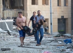 Wounded people are evacuated after a massive explosion in Beirut, Lebanon, Tuesday, Aug. 4, 2020.