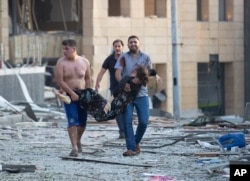 Wounded people are evacuated after a massive explosion in Beirut, Lebanon, Tuesday, Aug. 4, 2020.