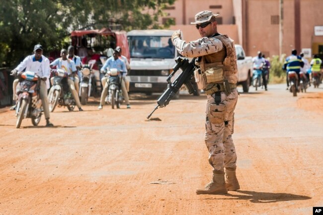 FILE - A soldier from Spain guards the European Union Training Mission (EUTM) camp in Koulikoro, Mali, Nov. 28, 2017.