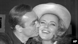 FILE - British actor Sean Connery kisses actress Honor Blackman at a party in Iver Heath, England, March 25, 1964. Blackman died of natural causes.