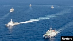 共同社2013年9月10日拍攝的照片顯示中國海警船和日本海上保安廳船隻在有爭議的東海島嶼附近對抗。