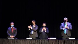 In this photo provided by Peg Shanahan, new Mayor Sokhary Chau, left, is applauded by councillors John Drinkwater, second from left, vice chair Erik Gitschier and Wayne Jenness during the Lowell City Council swearing-in ceremony, Monday, Jan. 3, 2022.