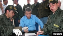 FILE - Colombian police fingerprint the former boss of the powerful Cali drug cartel, Miguel Rodriguez Orejuela, before being extradited to the United States at Palanquero military Base in Puerto Salgar, March 11, 2005.