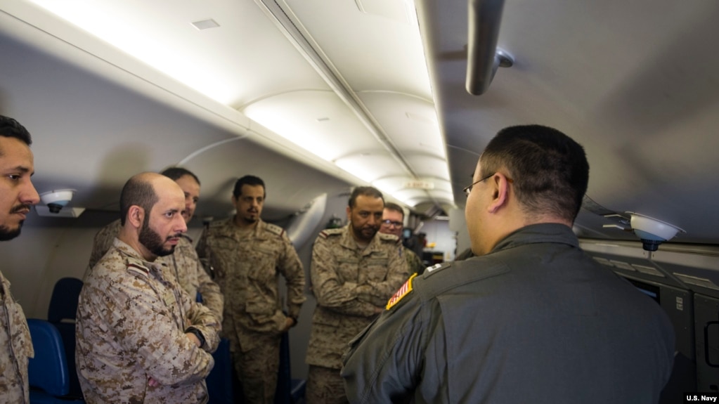 美国海军资料照片：分配入美国海军巡逻第5中队的战术协调员杨帆（右，音译）上尉在P-8A“海神”反潜飞机上向沙特皇家海军人员展示飞机的系统（美国海军2018年3月1日照片）(photo:VOA)
