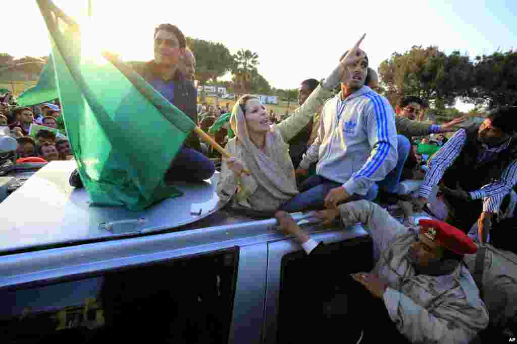 Aisha Kadhafi (no centro de braço erguido), filha de Muammar Kadhafi, juntou-se a manifestantes que formaram um escudo humano em redor de um palácio do líder líbio.