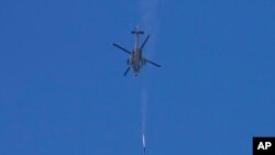 FILE - An Israeli Apache helicopter fires a missile in direction of the Gaza Strip, as seen from southern Israel, December 4, 2023.