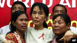 Aung San Suu Kyi (C) comforts crying HIV/AIDS infected people during a visit to the National League for Democracy (NLD) party headquarters to mark World AIDS Day in Yangon December 2, 2010. REUTERS/Soe Zeya Tun (MYANMAR - Tags: HEALTH POLITICS IMAGES OF 