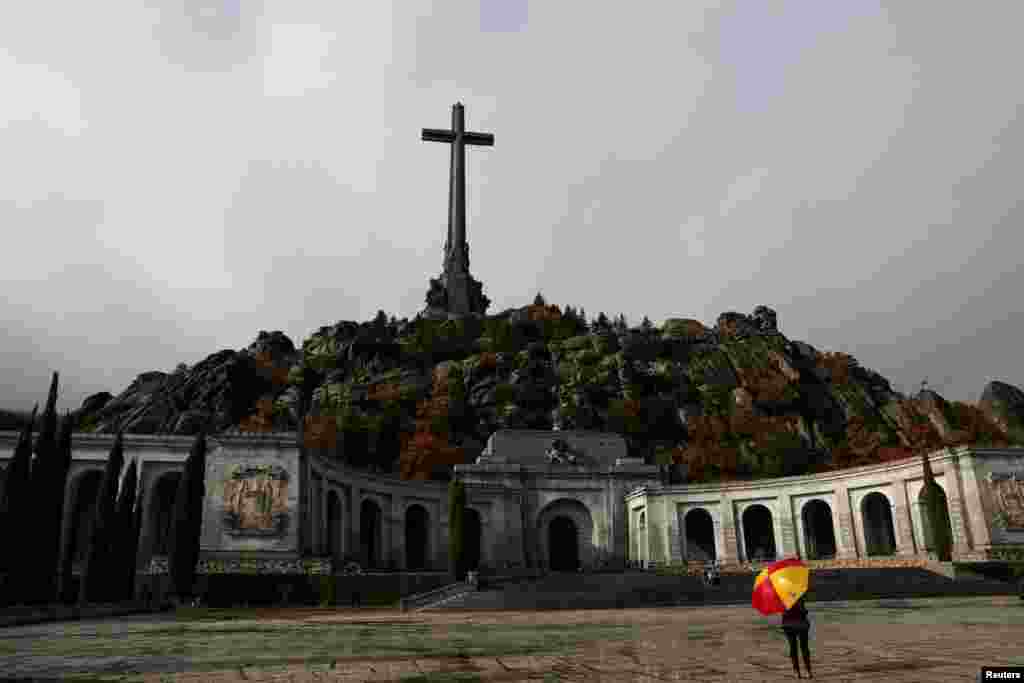 A woman holds an umbrella at the Valle de los Caidos (The Valley of the Fallen) &mdash; the mausoleum where the remains of former Spanish dictator Francisco Franco are kept &mdash; in San Lorenzo de El Escorial, outside Madrid, Spain.