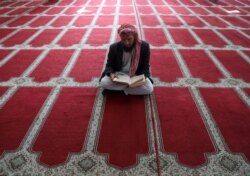 Seorang pria Afghanistan membaca al-Quran di sebuah masjid selama bulan suci Ramadhan di Kabul, Afghanistan 18 April 2021. (Foto: REUTERS/Omar Sobhani)