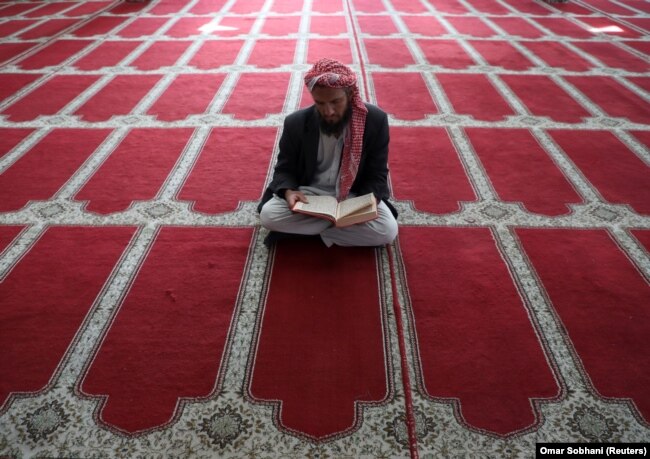 Seorang pria Afghanistan membaca al-Quran di sebuah masjid selama bulan suci Ramadhan di Kabul, Afghanistan 18 April 2021. (Foto: REUTERS/Omar Sobhani)