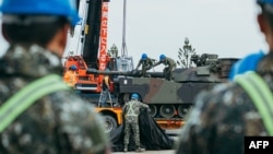 This handout photo taken and released on Dec. 16, 2024, by Taiwan's defense ministry shows soldiers securing a U.S.-made M1A2 Abrams battle tank onto a trailer at an army training center in Hsinchu county, Taiwan.