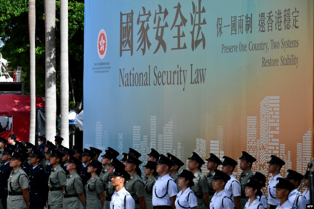资料照：香港警察站在宣传香港国安法的宣传牌前。（2020年7月1日）(photo:VOA)