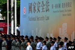 资料照：香港警察站在宣传香港国安法的宣传牌前。（2020年7月1日）
