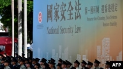 资料照：香港警察站在香港国安法的宣传牌下。（2020年7月1日）