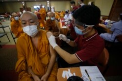 Seorang petugas kesehatan memberikan dosis vaksin Sinovac COVID-19 kepada biksu Buddha di Rumah Sakit Imam di Bangkok, Thailand, Selasa, 18 Mei 2021. (Foto: AP)