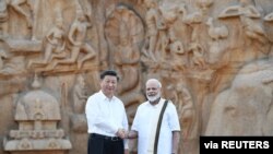 Indians hold a banner welcoming Chinese President Xi Jinping outside the airport in Chennai, India, Oct. 11, 2019.