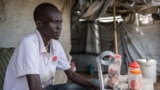 FILE -- Mod James, 27, who is blind and has recently developed an undiagnosed muscle disease that has made him unable to walk sits and sells sweets at Mahad camp for internally displaced people (IDP) in Juba, April 17, 2018. 