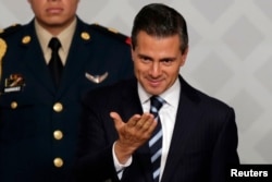 Mexico's President Enrique Pena Nieto gestures during an event with lawyers in Mexico City, Nov. 21, 2014.