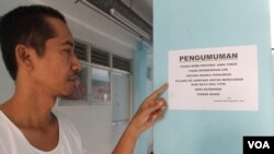 Iklil Almilai menunjukkan salah satu pengumuman larangan pulang kampung saat Idul Fitri bagi pengungsi Syiah Sampang di rusun. (VOA/Petrus Riski)