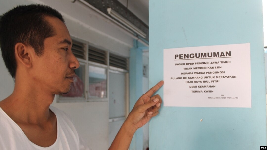 Iklil Almilai menunjukkan salah satu pengumuman larangan pulang kampung saat Idul Fitri bagi pengungsi Syiah Sampang di rusun. (VOA/Petrus Riski)