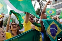 Supporters of Brazilian presidential candidate Jair Bolsonaro cheer as they gather outside his residence in Rio de Janeiro, Brazil, Sunday, Oct. 28, 2018, during the country's presidential runoff election.